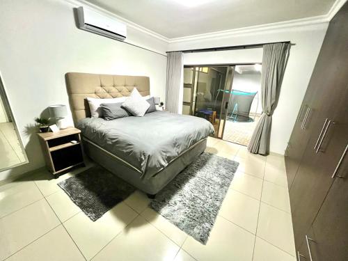 a bedroom with a bed and a door to a room at Crossroads Luxury Accommodation in Swakopmund