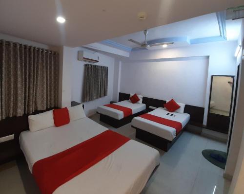 a hotel room with two beds and a couch at hotel royal night in Ahmedabad
