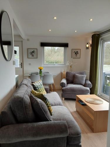 a living room with a couch and a table at Chalet 176 Glan Gwna Park Caernarfon in Caeathro