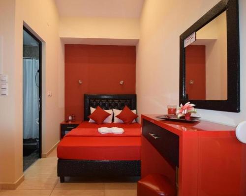 a red bedroom with a red bed and a mirror at Apartments Vesna Luxury ap 5 & 6 Paralia in Paralia Katerinis