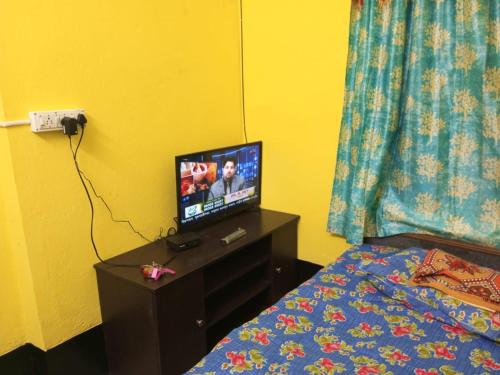 um quarto com uma cama e uma televisão numa mesa em SPG HOLIDAY em kolkata