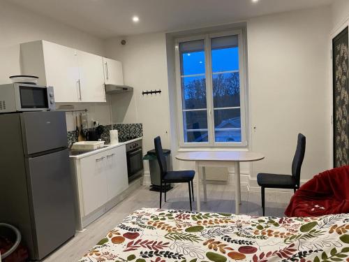 a kitchen with a table and chairs in a room at Studio meublé et lumineux 20m2 in Vittel