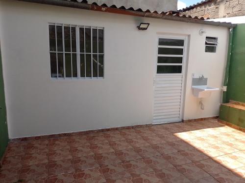 uma garagem branca com uma porta e um lavatório em Casa para Lollapalooza em São Paulo
