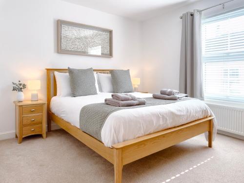 a bedroom with a large bed with two pillows on it at Salters Cottage - Stunning Modernised 3 BR Home Just Steps From the Beach in Budleigh Salterton
