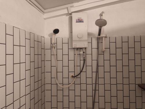 a shower in a bathroom with tiled walls at Odambang Village Homestay in Battambang