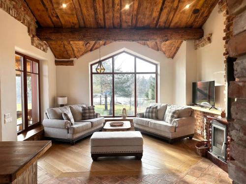 a living room with two couches and a fireplace at Dabintos slėnis in Sumiliszki