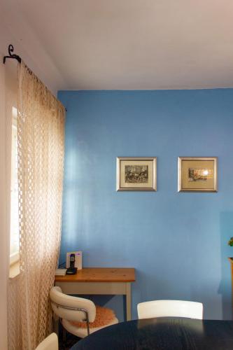 a room with a table and a blue wall at Divna Apartments and Rooms in Račišće