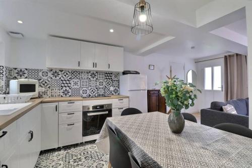 une cuisine avec une table avec un vase de fleurs dessus dans l'établissement La Dolce Vita, jolie maison familiale, à Troyes