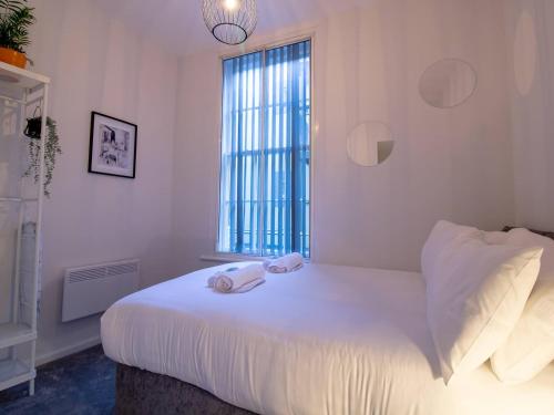 um quarto com uma cama com duas toalhas em Pass the Keys Modern Apartment in the Heart of Newcastle em Newcastle upon Tyne