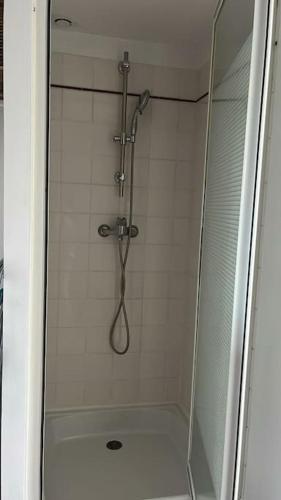 une douche avec une porte vitrée dans une salle de bain dans l'établissement Studio proche du centre-ville, à La Rochelle
