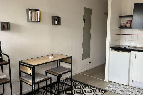 une cuisine avec une table, deux chaises et un comptoir dans l'établissement Studio proche du centre-ville, à La Rochelle