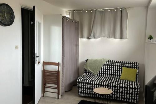 un soggiorno con un divano bianco e nero e una finestra di Studio proche du centre-ville a La Rochelle