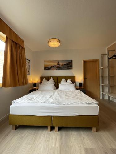 a bedroom with a large bed with white sheets and pillows at TuS-FeWo#04 - Serviced & Executive Apartments in Mönchengladbach