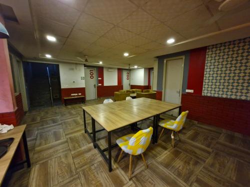 Habitación con mesa de madera y sillas. en Hotel Wedlock 39 en Gurgaon