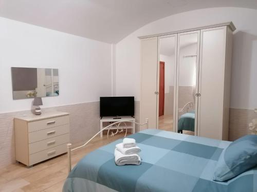 a bedroom with a blue bed and a television at Sapore di mare house in Bari
