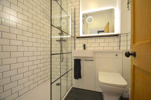een badkamer met een toilet, een wastafel en een spiegel bij The Gate Lodge in Helensburgh