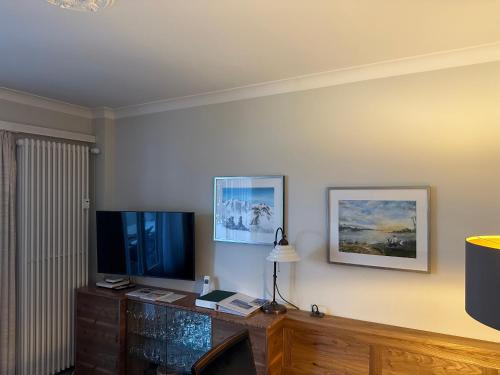 a living room with a tv and a table with a lamp at Chesa Derby 32 in St. Moritz