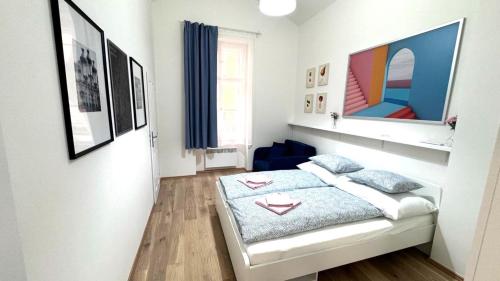 um pequeno quarto com uma cama e algumas fotografias em Side Street Apartments em Praga