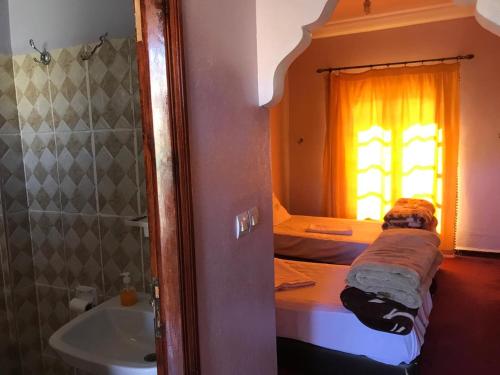 een slaapkamer met een bed, een wastafel en een raam bij SEVEN DAYS HOTEL in Toufleht