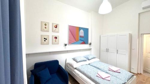 um pequeno quarto com uma cama e uma cadeira azul em Side Street Apartments em Praga