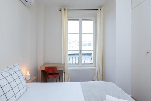 une chambre blanche avec un lit et une fenêtre dans l'établissement Villa CANA, à Cannes