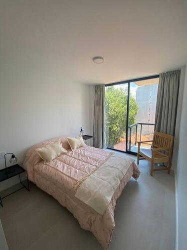 a bedroom with a large bed and a balcony at Zona Güemes 2 ambiente N 503 in Mar del Plata
