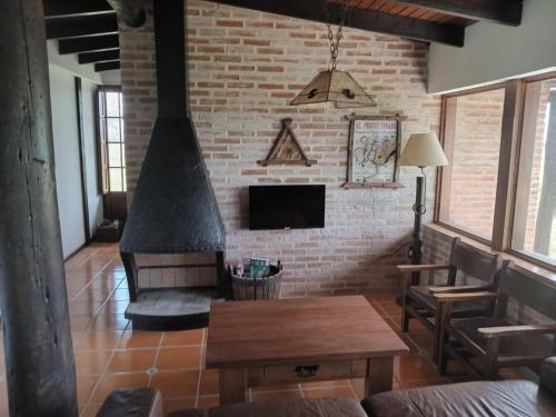 sala de estar con pared de ladrillo y chimenea en Casa de campo en Los Cerrillos, en Los Cerrillos