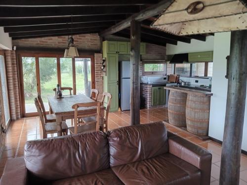 sala de estar con sofá de cuero y mesa en Casa de campo en Los Cerrillos, en Los Cerrillos