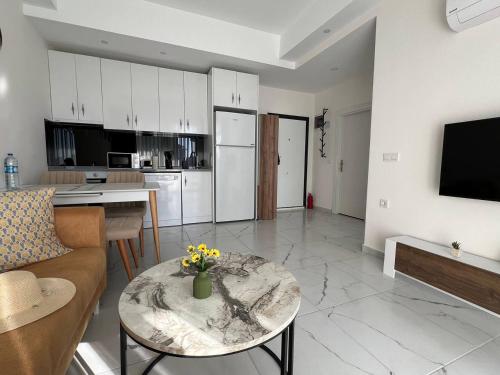 a living room with a table and a kitchen at Art life apart (Meadow) in Alanya