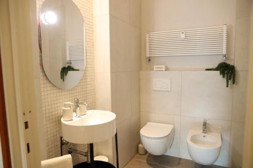 uma casa de banho com um lavatório, um WC e um espelho. em Casa moderna nel centro di Imola em Imola