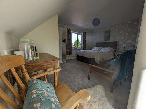 a bedroom with a bed and a desk and a table at Pool Farm in Redditch