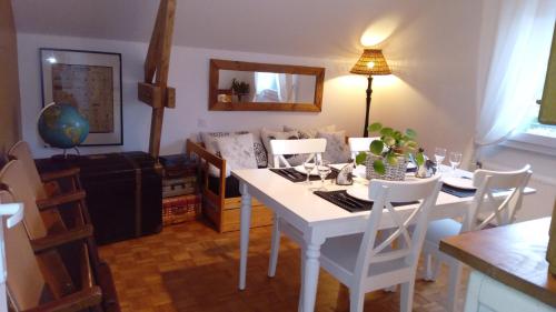 Au Duc de Sep في Sepmeries: مطبخ مع طاولة بيضاء وكراسي وغرفة