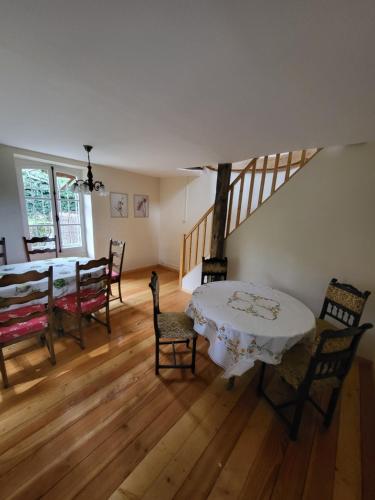 une salle à manger avec une table, des chaises et un escalier dans l'établissement Vue Du Vallon, à Bersac-sur-Rivalier