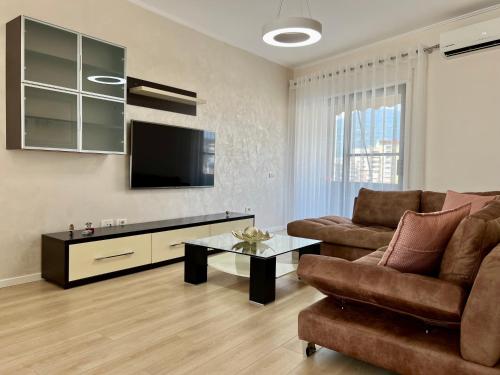 ein Wohnzimmer mit einem Sofa und einem TV in der Unterkunft New Bazaar Cozy Apartments Apartment 1 Apartment 2 in Tirana