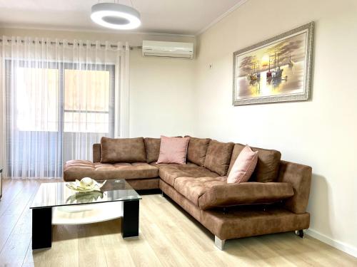 een woonkamer met een bruine bank en een tafel bij New Bazaar Cozy Apartments - Apartment 1 , 2 , 3 and 4 in Tirana