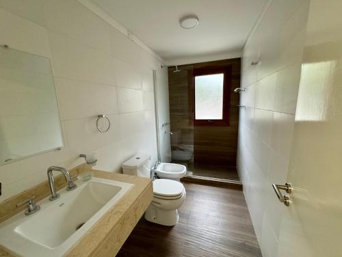 uma casa de banho branca com um WC e um lavatório em BuenaVid estancias em Cafayate