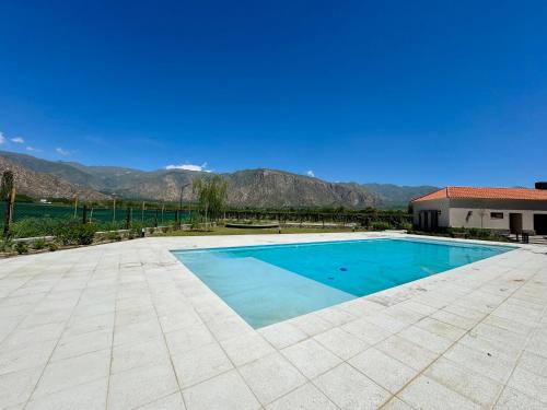 a large swimming pool with mountains in the background at BuenaVid estancias in Cafayate