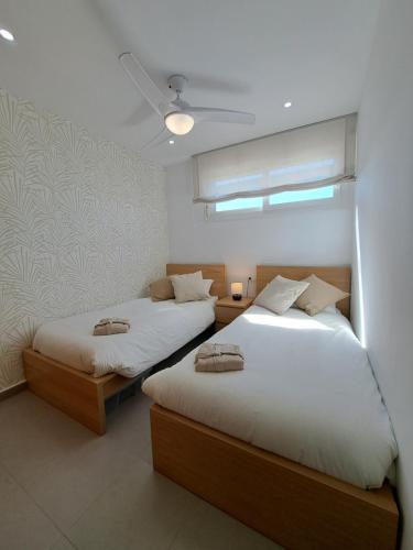 1 dormitorio con 2 camas y ventana en Casa Raya, en Roldán