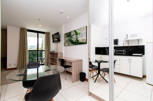 a kitchen and dining room with a glass table and chairs at BSB STAY Flats particulares - Athos SHN in Brasília