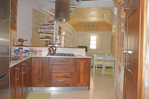 y cocina con armarios de madera y fogones. en That Little (Old) House en Żurrieq