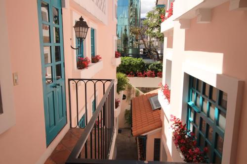 an alley in a city with a blue door and flowers at Hotel Boutique Vieja Cuba in Quito