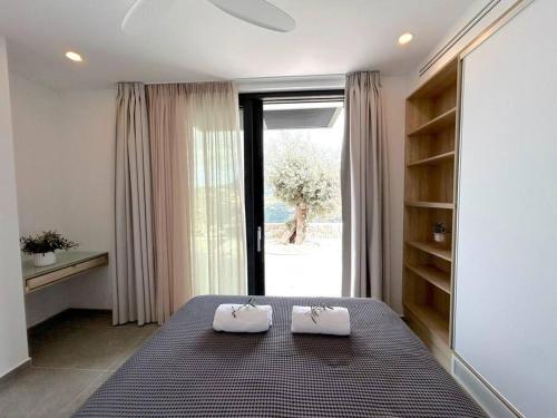 a bedroom with a bed with two towels on it at Go-Blue Star, Villa Sea in Sivota