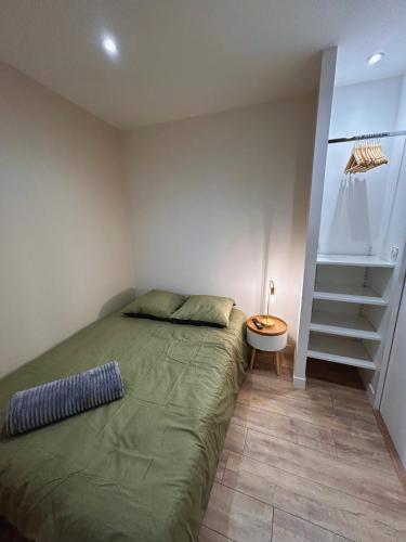 - une chambre avec un lit vert et un escalier dans l'établissement Le Cocon Citadin, à Millau