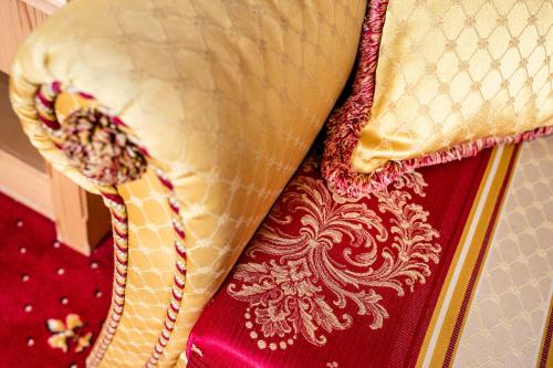 a close up of a bed with a red and gold pillow at Engels Park in Vipiteno