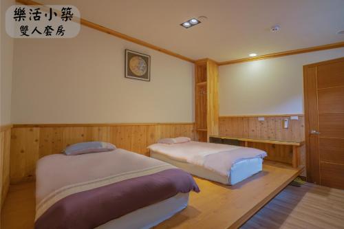 Zimmer mit 2 Betten in einem Zimmer mit einem Bildschirm in der Unterkunft 江山樂活Lohas in Puli