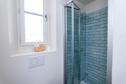 une salle de bain avec une douche en verre avec une fenêtre dans l'établissement Villa CANA, à Cannes