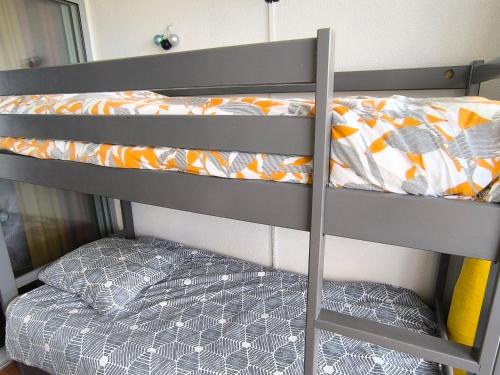- un lit superposé avec une couette orange et grise dans l'établissement Appartement de vacances - Splendide vue sur mer, Parking privé, au Barcarès