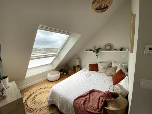 une chambre avec un lit et une grande fenêtre dans l'établissement Cottage les pieds dans l'eau, à Montfarville