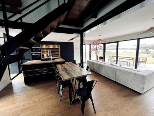une grande cuisine avec une grande table et un canapé dans l'établissement Cottage les pieds dans l'eau, à Montfarville