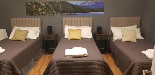 um quarto com 2 camas individuais e almofadas em Casa Magallanes em Ushuaia